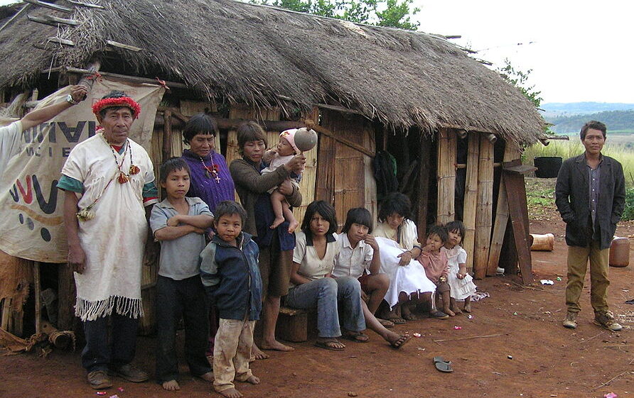 Pai Tavytera people in front of a house in Paraguay. FrankOWeaver, CC BY-SA 3.0 , via Wikimedia Commons