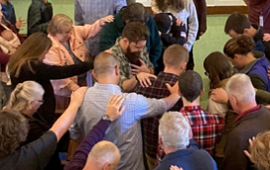 People gather round to pray for an SIM worker. Pic by SIM photographer